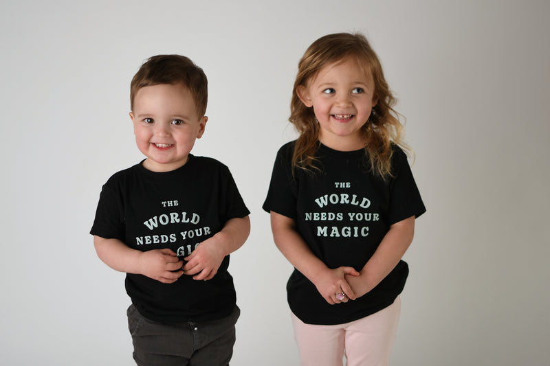 THE WORLD NEEDS YOUR MAGIC KIDS TEE IN BLACK – Storied Folk &