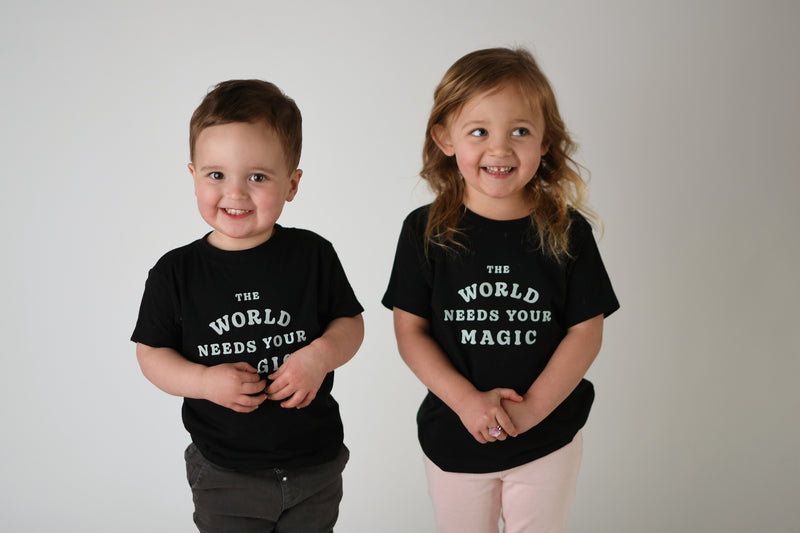 THE WORLD NEEDS YOUR MAGIC KIDS TEE IN BLACK